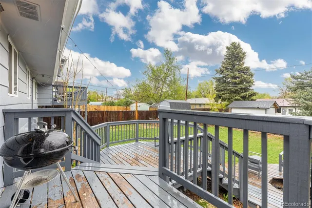 a view of a balcony with wooden floor and outdoor seating