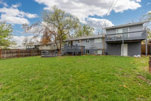a front view of a house with a garden and trees