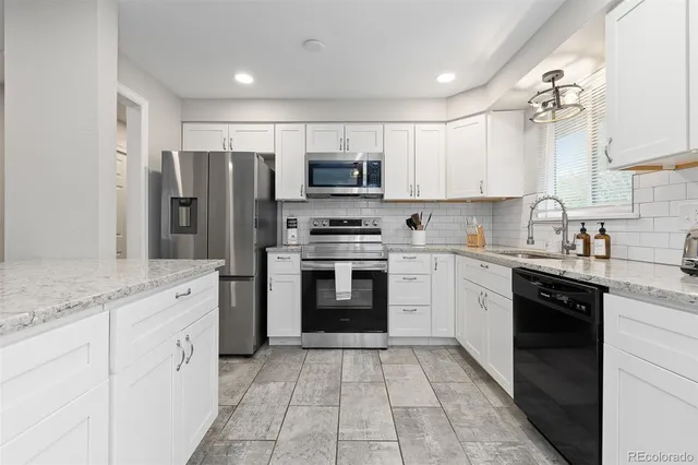 a kitchen with stainless steel appliances granite countertop a refrigerator and a stove top oven