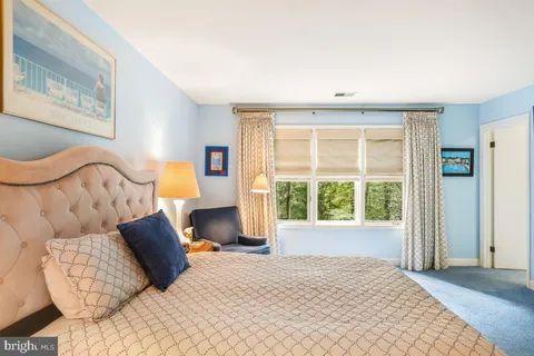 a bedroom with furniture and a large window