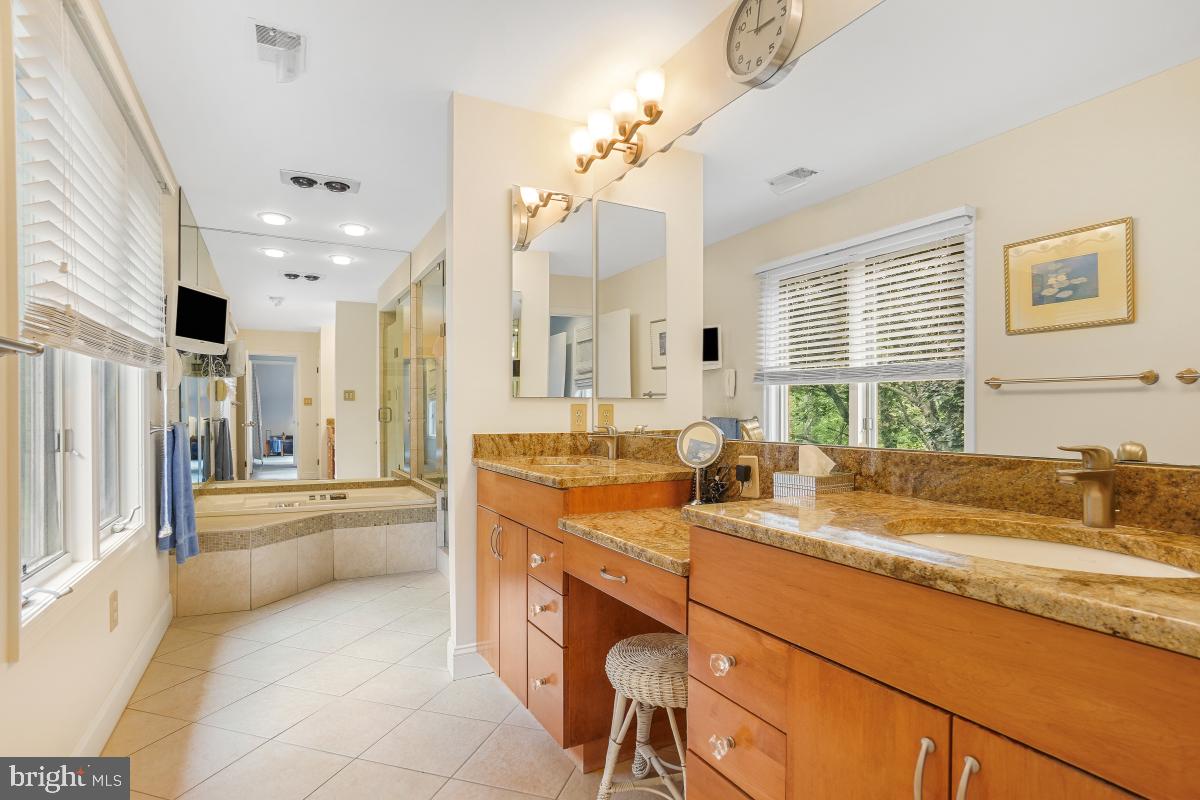 11521 Twining Lane Potomac, MD 20854 - Photo 20 of 31 a bathroom with a granite countertop sink mirror and a bath tub