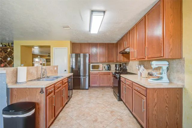 a kitchen with stainless steel appliances granite countertop a sink a stove and a refrigerator