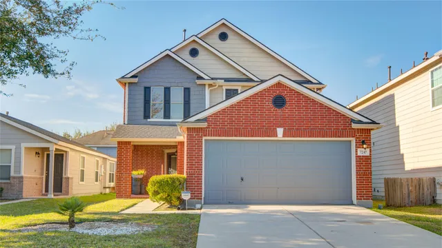 a front view of a house with yard and garage