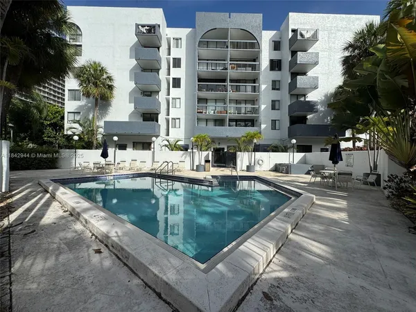 a view of building with swimming pool and sitting area