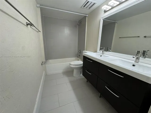 a bathroom with a double vanity sink toilet and shower