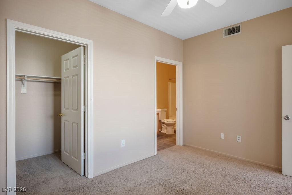 4655 Gold Dust Avenue, Unit 211 Las Vegas, NV 89120 - Photo 13 of 24 Unfurnished bedroom with light colored carpet, a closet, a ceiling fan, and ensuite bath