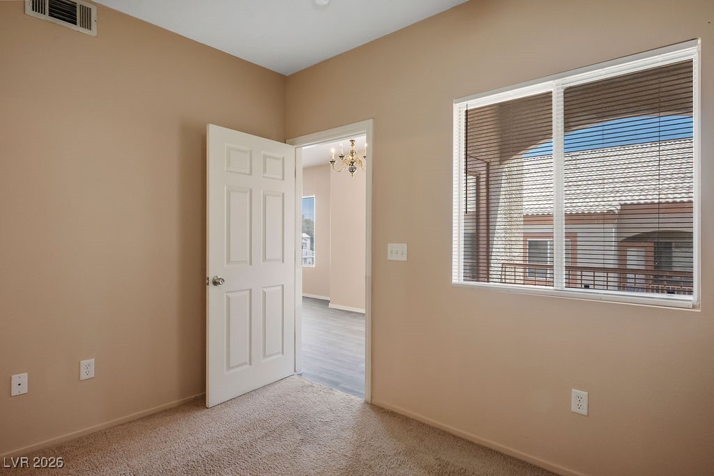 4655 Gold Dust Avenue, Unit 211 Las Vegas, NV 89120 - Photo 14 of 24 Unfurnished room with carpet and a chandelier