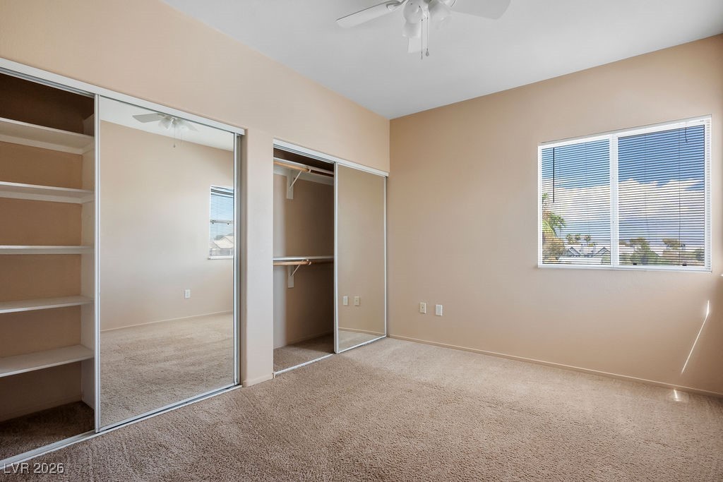 4655 Gold Dust Avenue, Unit 211 Las Vegas, NV 89120 - Photo 17 of 24 Unfurnished bedroom with two closets, carpet, and a ceiling fan