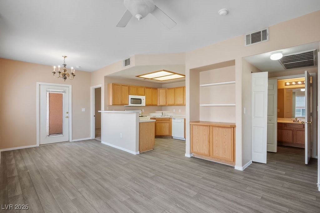 4655 Gold Dust Avenue, Unit 211 Las Vegas, NV 89120 - Photo 3 of 24 Kitchen featuring light countertops, a chandelier, a ceiling fan, white appliances, and light wood-type flooring