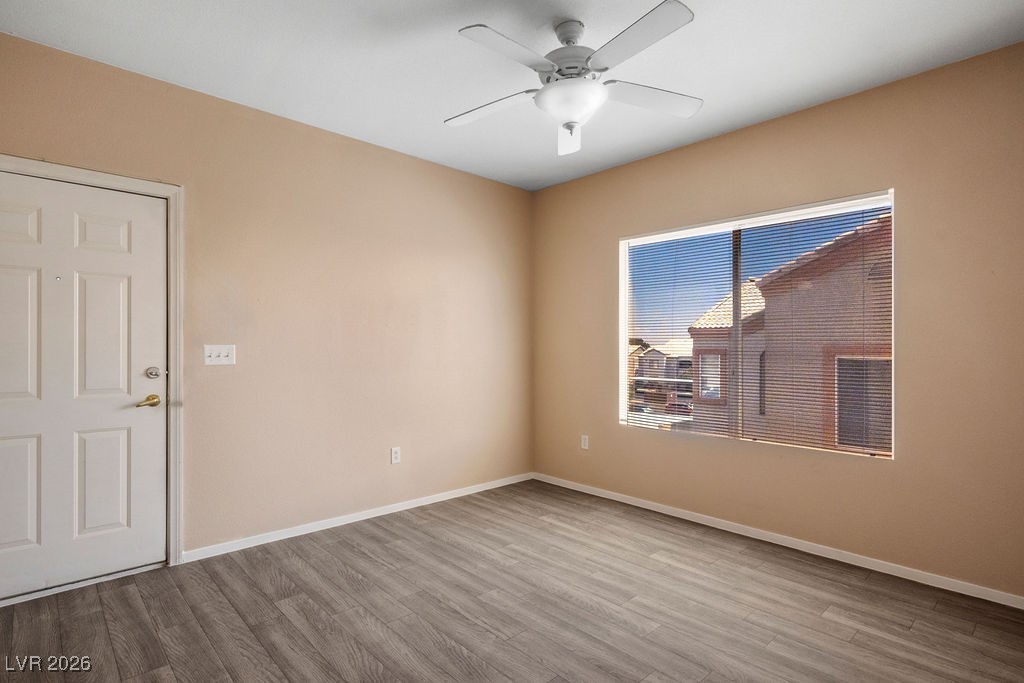 4655 Gold Dust Avenue, Unit 211 Las Vegas, NV 89120 - Photo 5 of 24 Empty room featuring wood finished floors and ceiling fan
