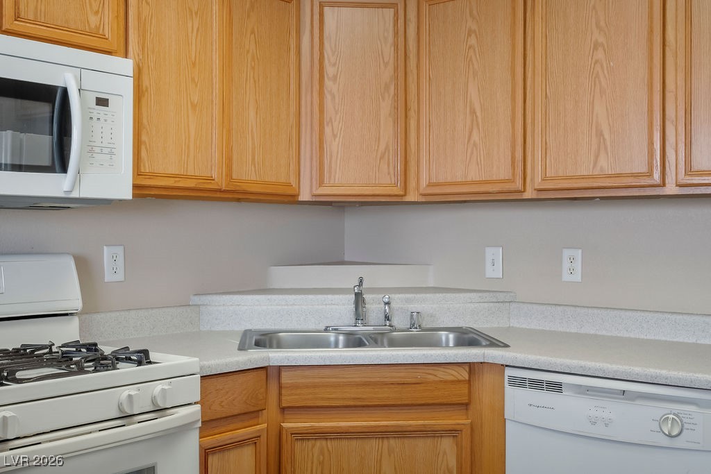 4655 Gold Dust Avenue, Unit 211 Las Vegas, NV 89120 - Photo 9 of 24 Kitchen with white appliances and light countertops