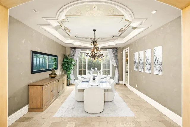 a dining room with chandelier fan and wooden floor