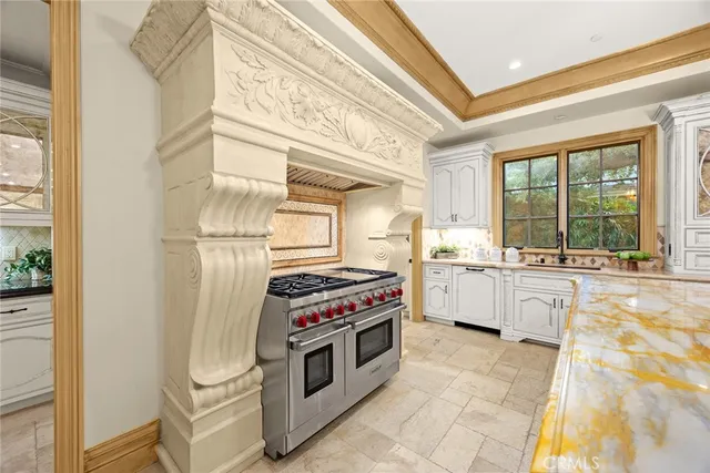 a kitchen with granite countertop a sink stove and cabinets