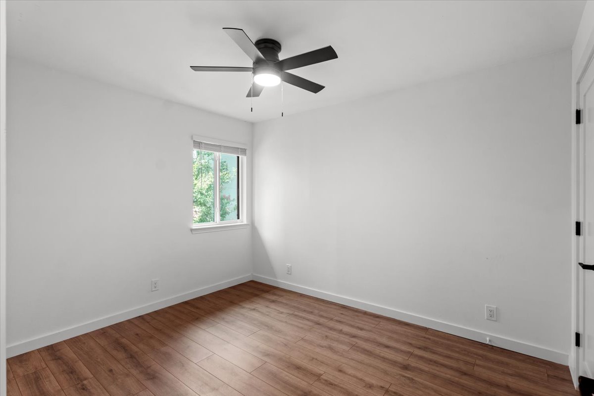 2500 Enfield Road, Unit 1 Austin, TX 78703 - Photo 18 of 26 The well-lit 2nd floor bedroom #1 features rich wood flooring and a modern ceiling fan.