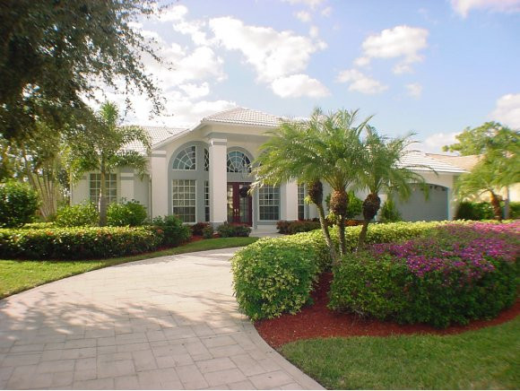 8949 Lely Island Circle Naples, FL 34113 - Photo 1 of 11 a front view of a house with garden