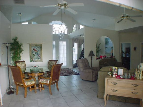 8949 Lely Island Circle Naples, FL 34113 - Photo 2 of 11 a living room with furniture and a chandelier