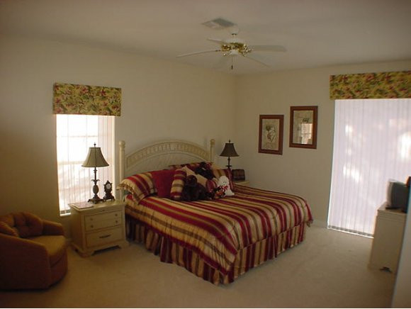 8949 Lely Island Circle Naples, FL 34113 - Photo 5 of 11 a bedroom with two beds and a chandelier