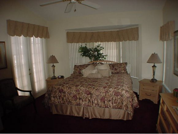 8949 Lely Island Circle Naples, FL 34113 - Photo 6 of 11 a bedroom with a bed dresser and a window