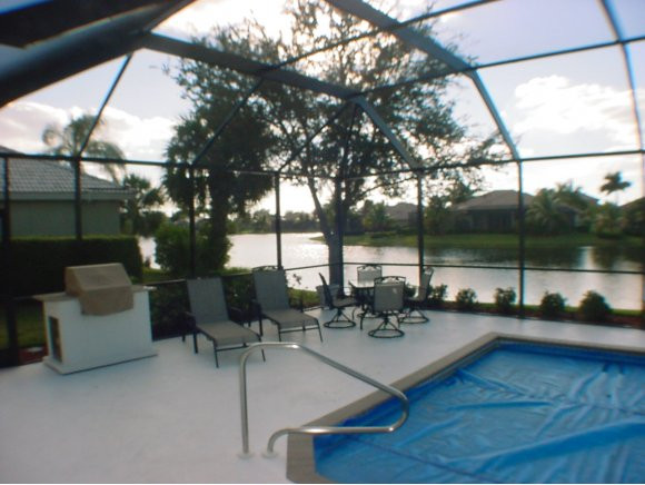 8949 Lely Island Circle Naples, FL 34113 - Photo 7 of 11 a living room with couches and dining table with a backyard