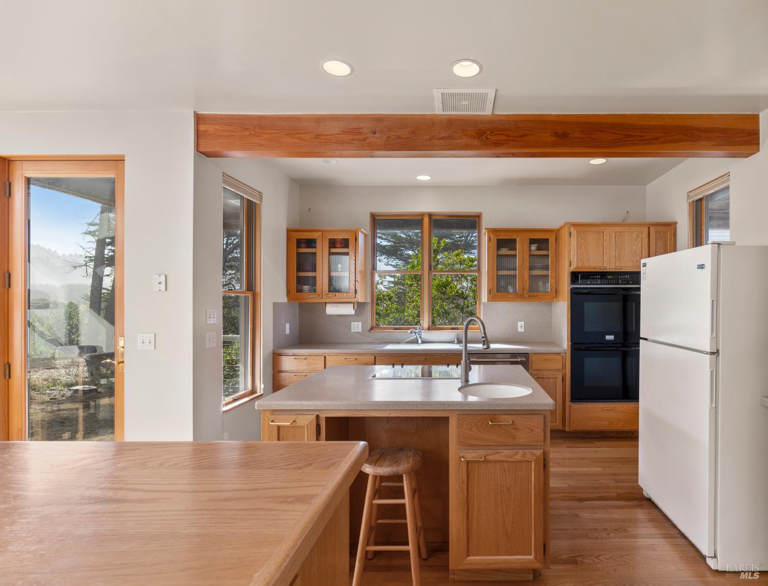 116 Shepherds Close The Sea Ranch, CA 95497 - Photo 8 of 65 a kitchen with granite countertop a refrigerator a stove and a sink with wooden floor