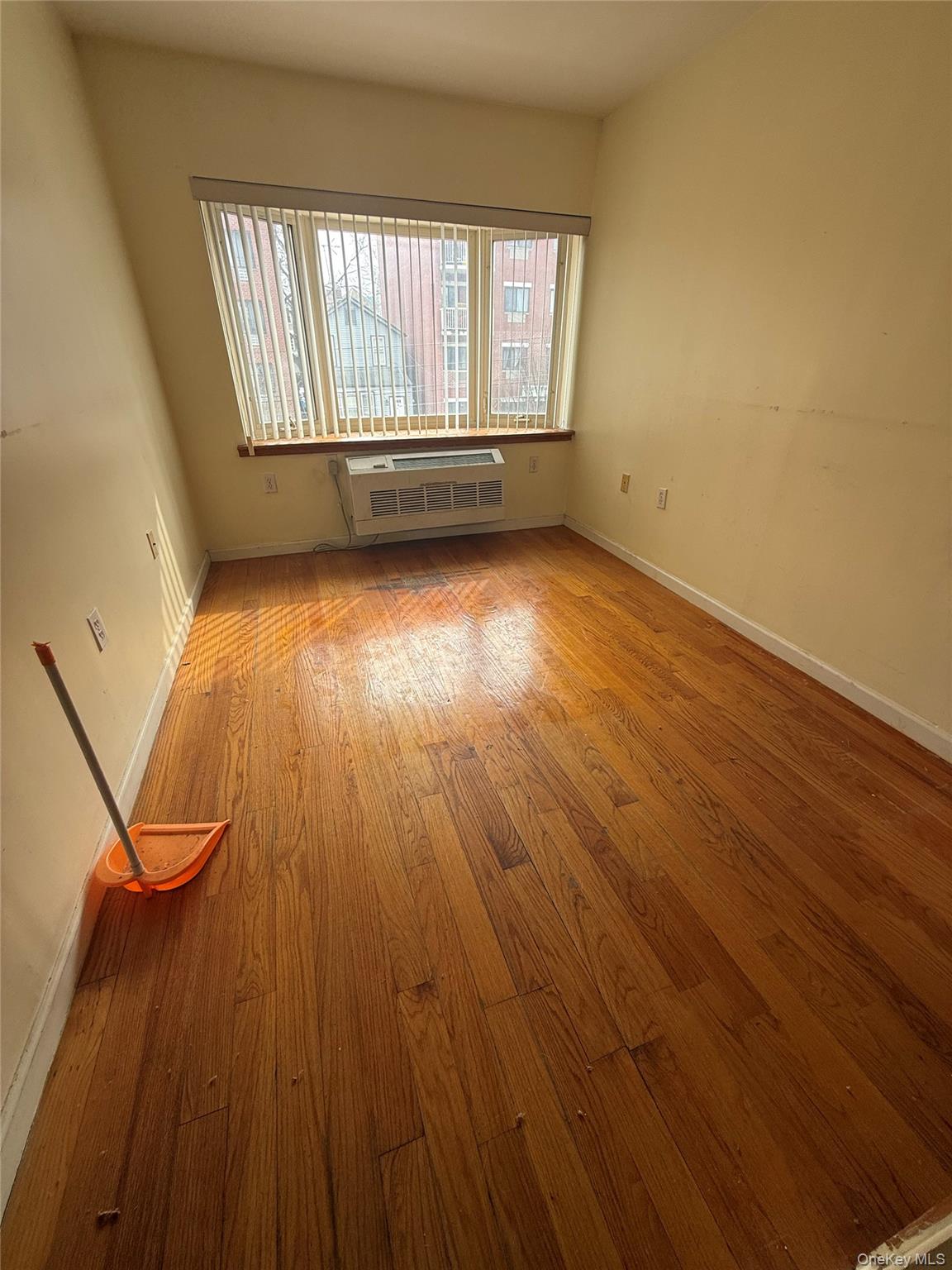 112-31 38th Avenue, Unit 3D Queens, NY 11368 - Photo 3 of 8 an empty room with wooden floor and windows