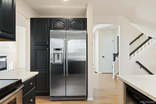 a kitchen with a refrigerator a sink and cabinets