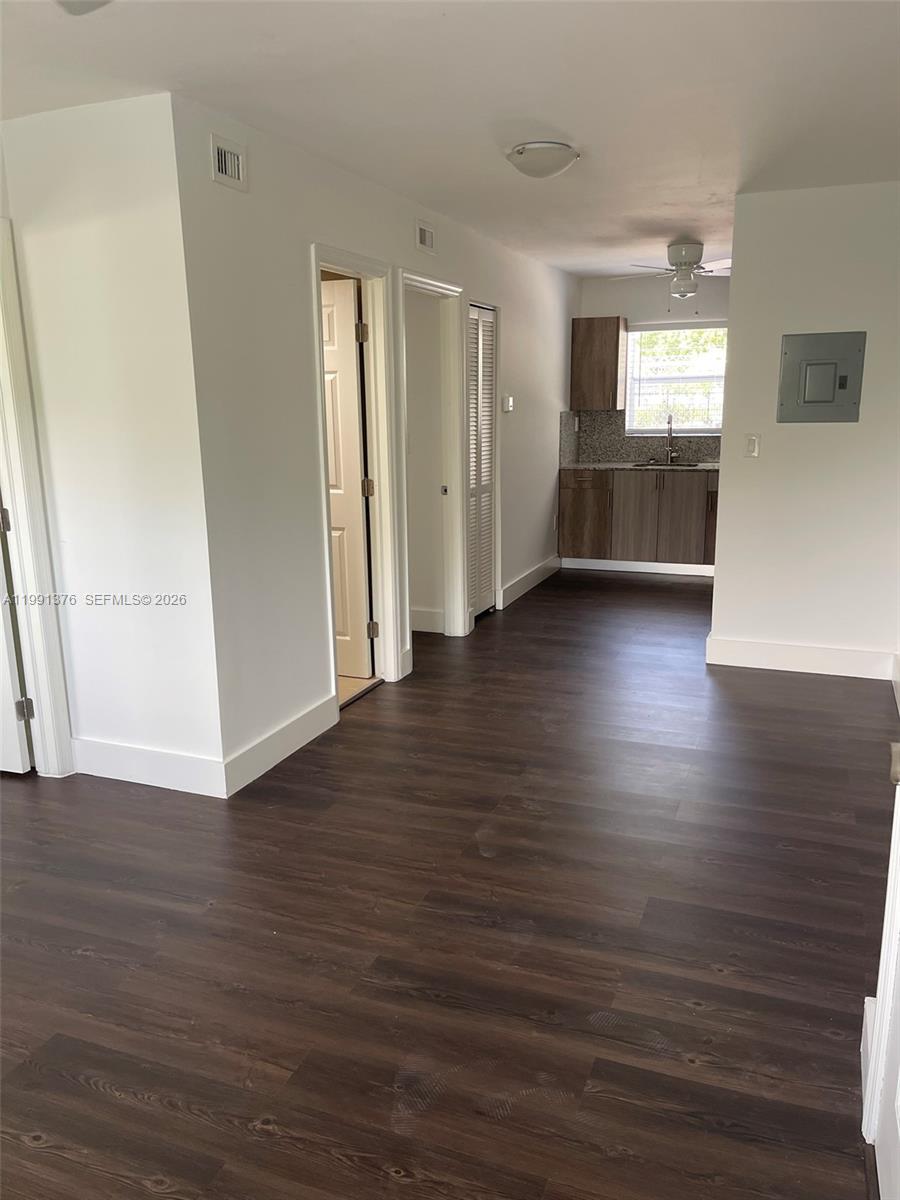 1864 Northwest 24th Street, Unit 4 Miami, FL 33142 - Photo 3 of 6 an empty room with wooden floor kitchen view and windows