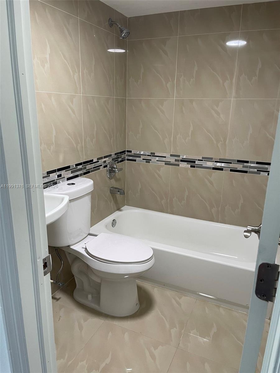 1864 Northwest 24th Street, Unit 4 Miami, FL 33142 - Photo 5 of 6 a white toilet sitting next to a bath tub