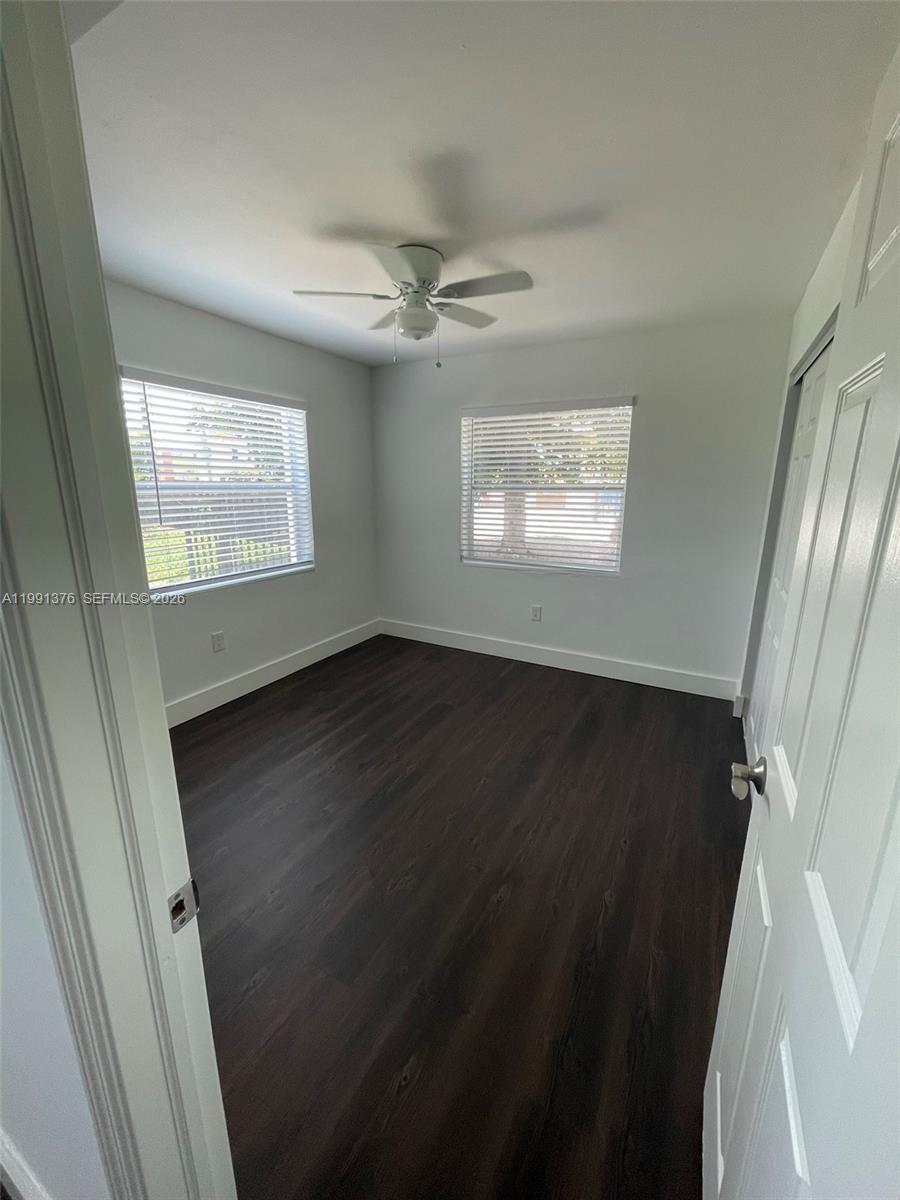 1864 Northwest 24th Street, Unit 4 Miami, FL 33142 - Photo 6 of 6 an empty room with wooden floor fan and windows