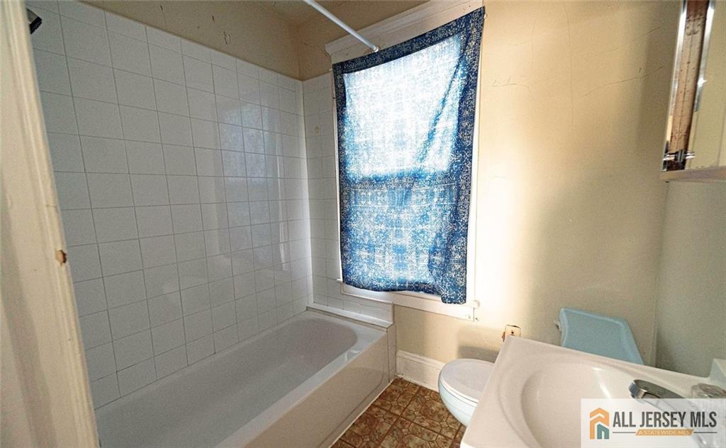 52 Ellen Street New Brunswick, NJ 08901 - Photo 3 of 5 a bathroom with a bathtub and shower