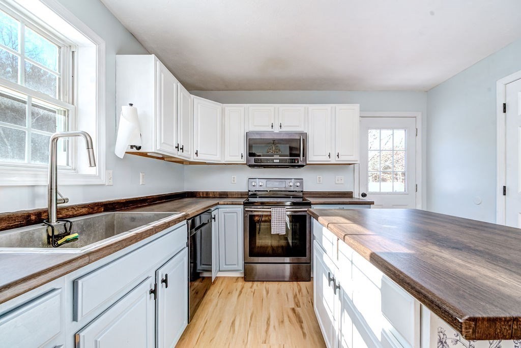 40 Sawyer Street Gardner, MA 01440 - Photo 9 of 37 a kitchen with kitchen island granite countertop a sink appliances cabinets and a counter top space