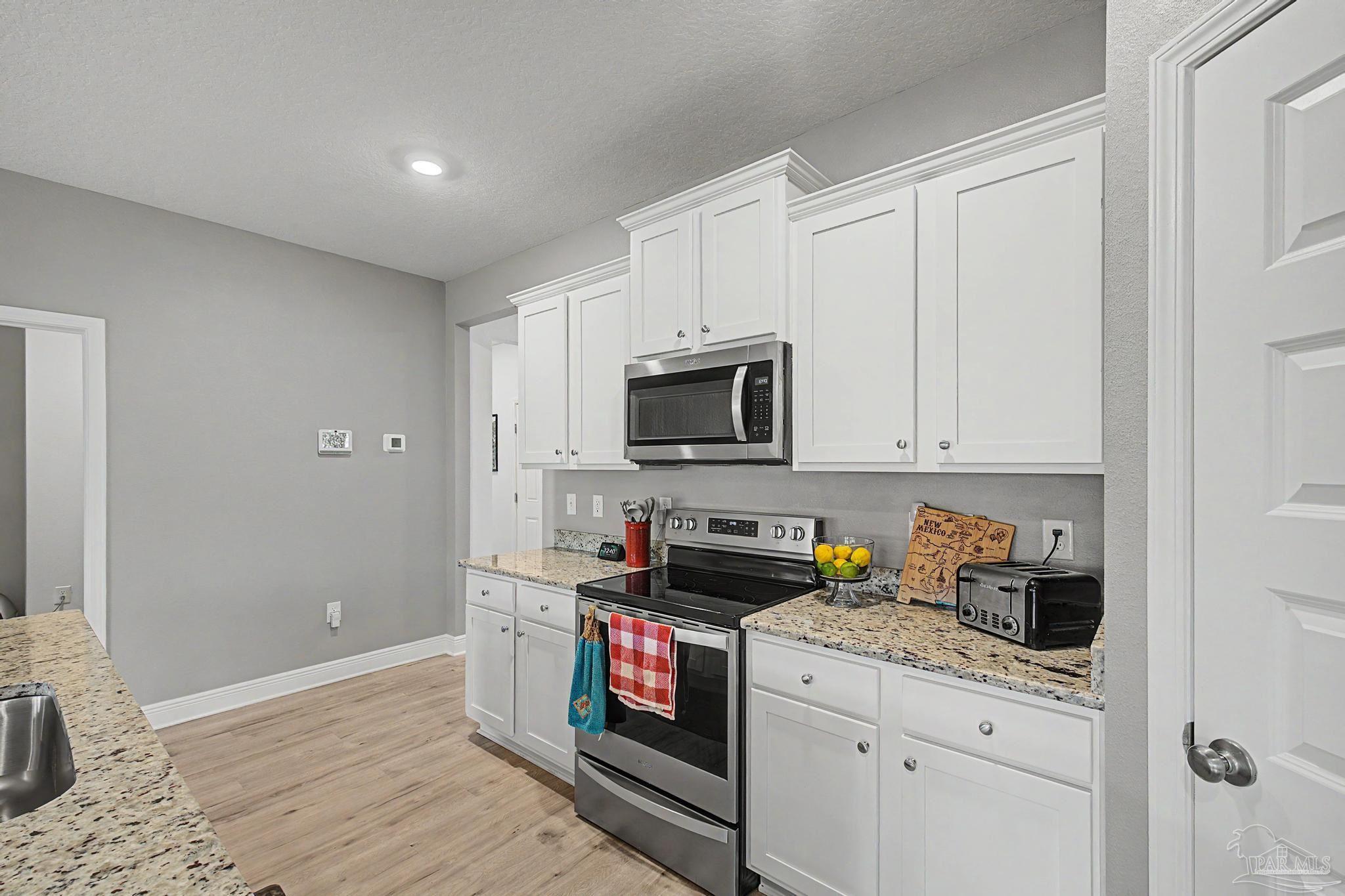 7902 Burnside Loop Pensacola, FL 32526 - Photo 10 of 47 a kitchen with stainless steel appliances granite countertop a stove a microwave and a refrigerator