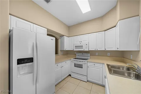 a kitchen with white cabinets and white appliances