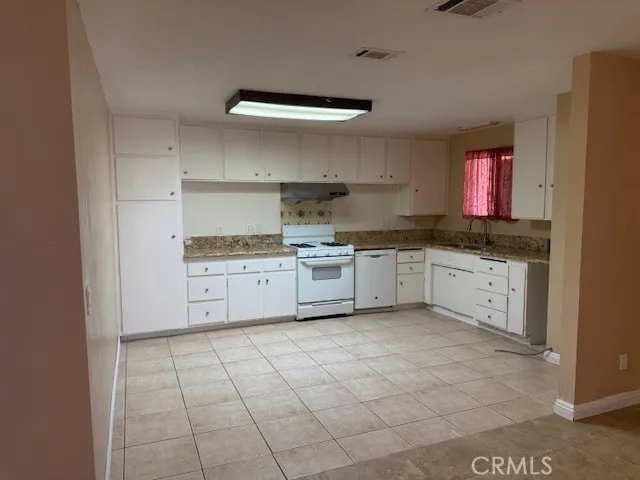 a kitchen with a sink a stove and cabinets