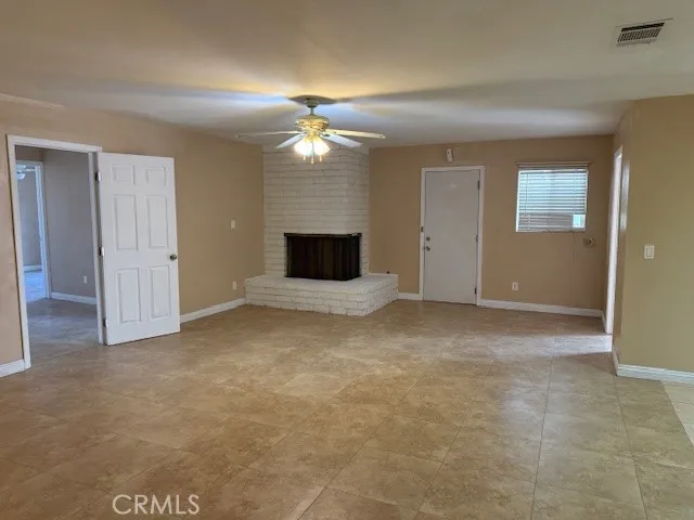 a view of a livingroom with an empty space and a ceiling fan