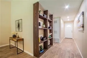 a view of a hallway with workspace and wooden floor