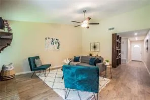 a living room with furniture and wooden floor