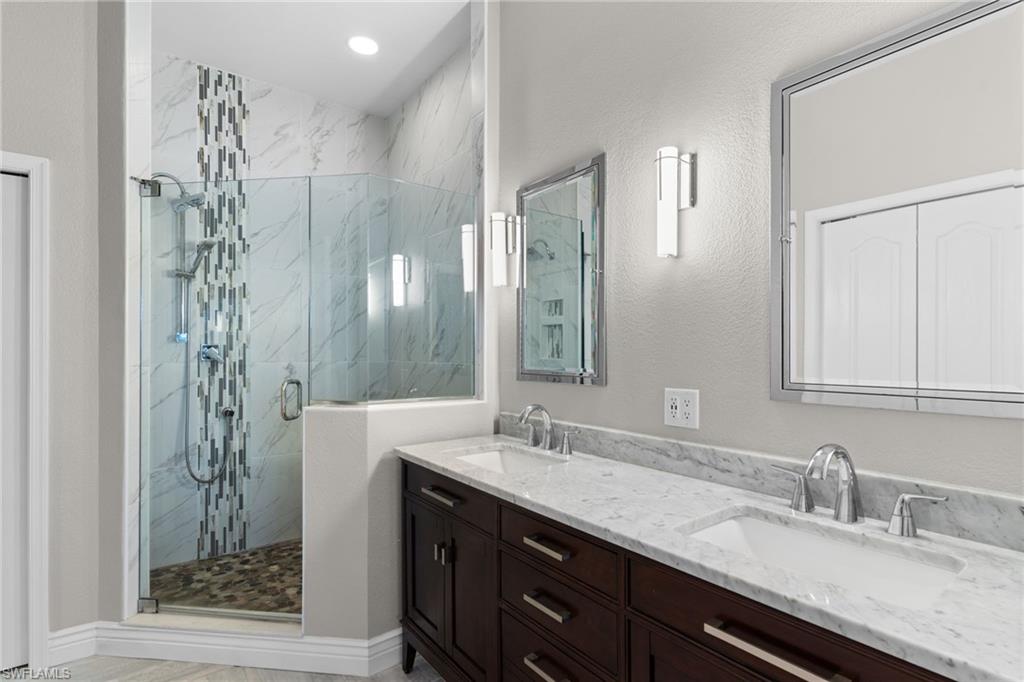 2421 Ravenna Boulevard, Unit 202 Naples, FL 34109 - Photo 14 of 42 a bathroom with double vanity and a mirror