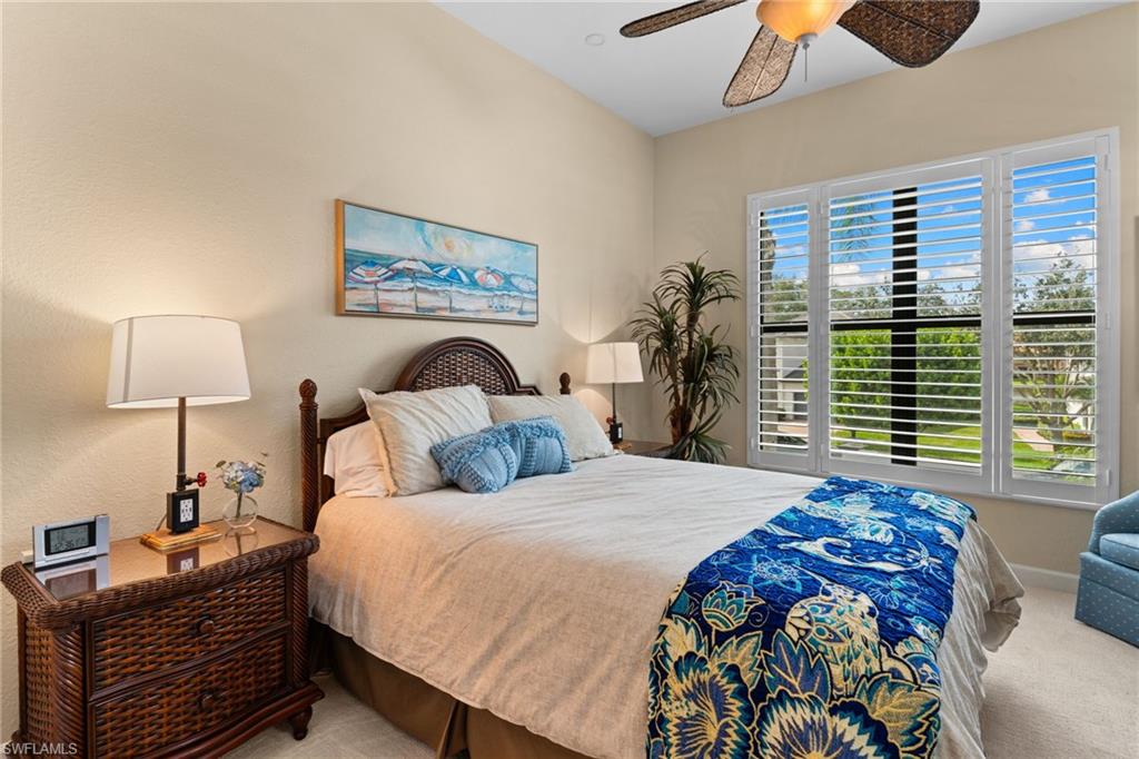 2421 Ravenna Boulevard, Unit 202 Naples, FL 34109 - Photo 15 of 42 a bedroom with a bed and a chandelier