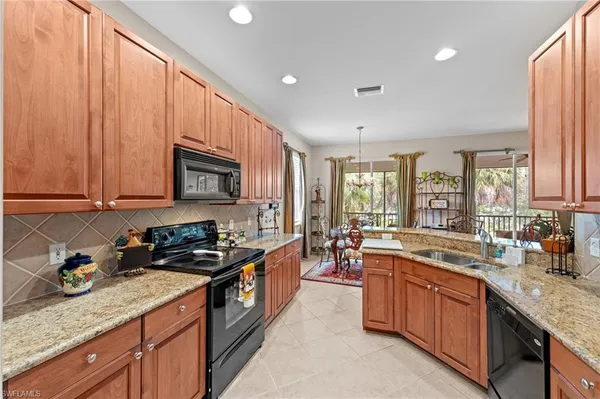 a large kitchen with stainless steel appliances granite countertop a lot of counter space and a sink