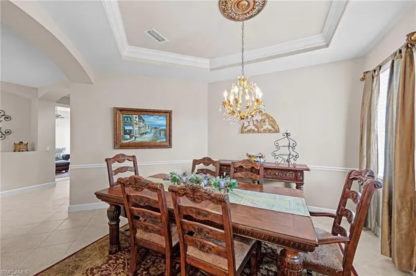 a dining room with furniture a chandelier and window