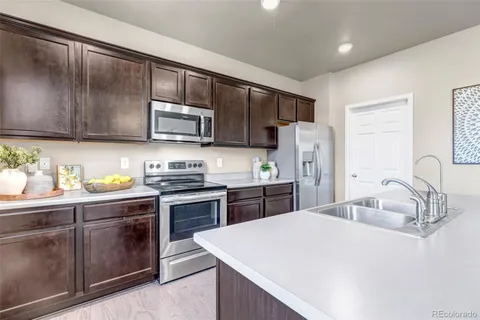 a kitchen with a sink stove and refrigerator