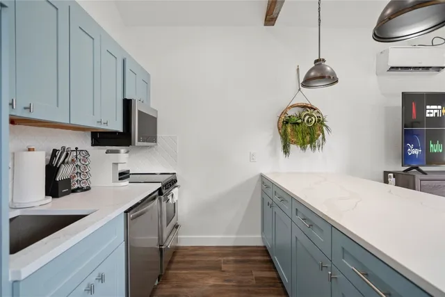 a kitchen with a sink dishwasher and a stove with wooden floor