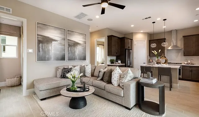 a living room with furniture and a view of kitchen