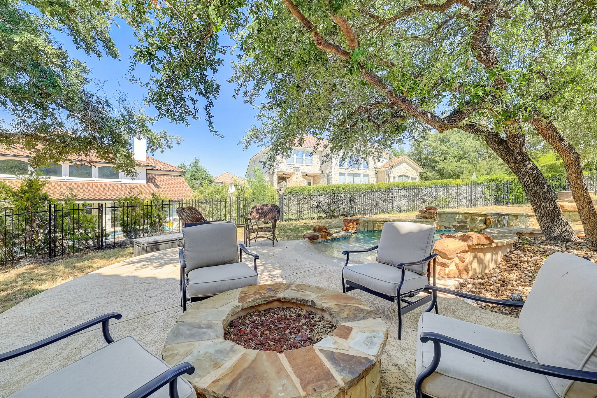 16012 Spillman Ranch Loop Austin, TX 78738 - Photo 32 of 38 An inviting stone fire pit area offers a tranquil outdoor retreat.