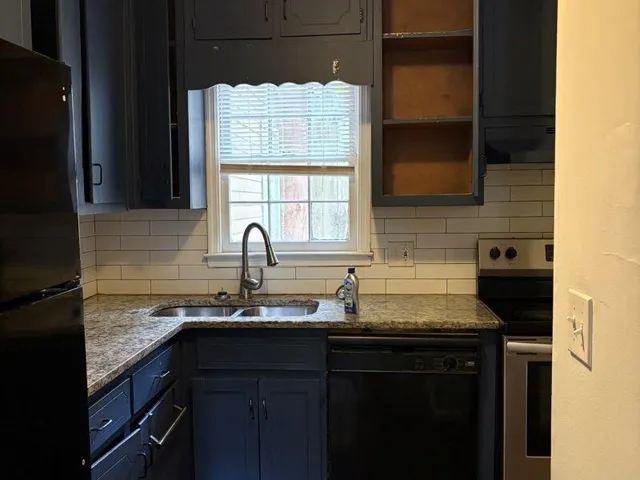 a kitchen with granite countertop a sink stove and refrigerator