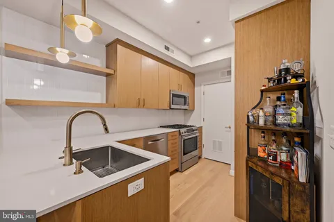 a kitchen with stainless steel appliances granite countertop a stove a sink and a refrigerator