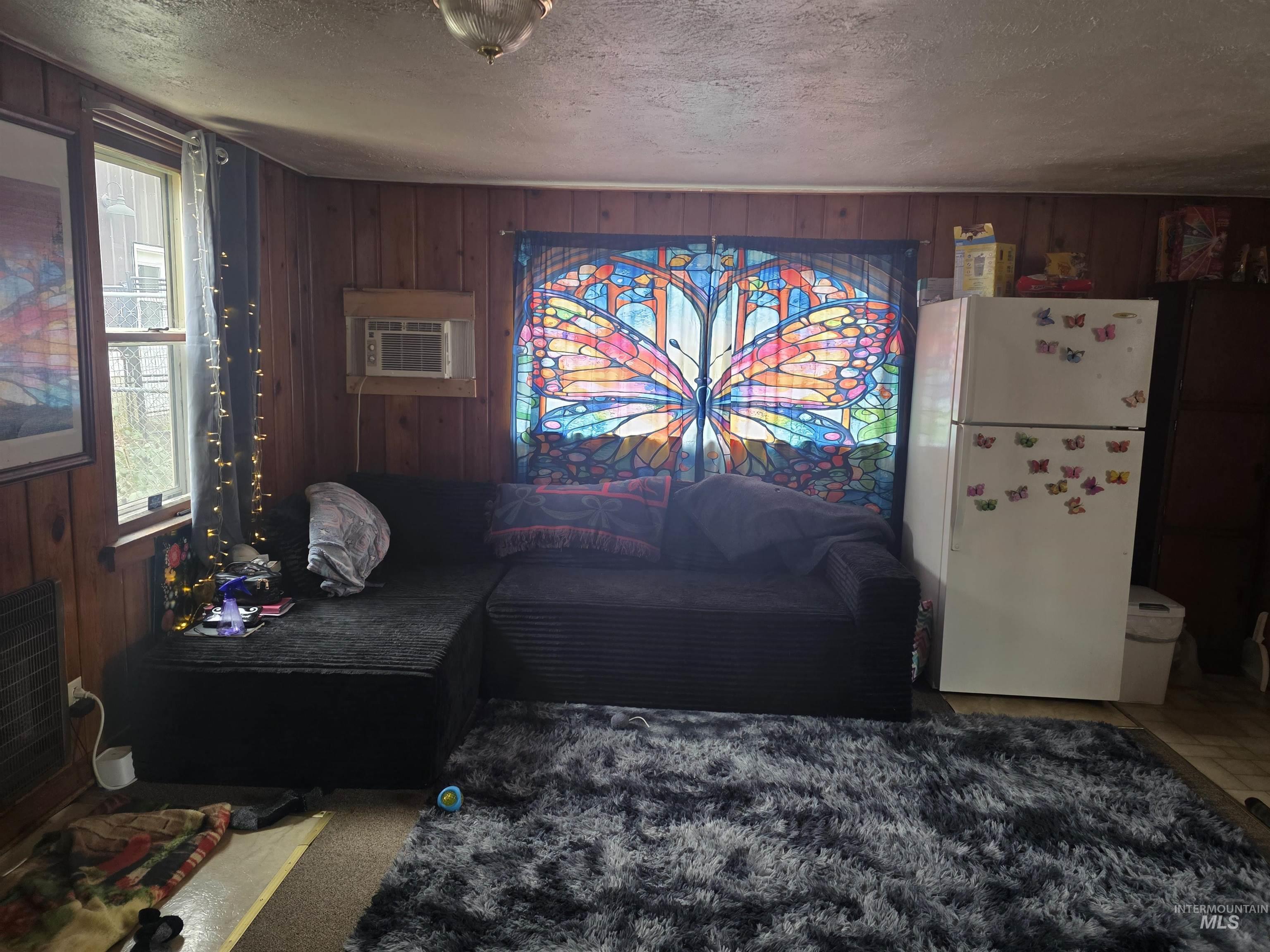 210 Pine Avenue Kooskia, ID 83539 - Photo 3 of 8 Living room with wood walls and a textured ceiling
