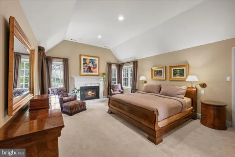 a spacious bedroom with a large bed and a fireplace