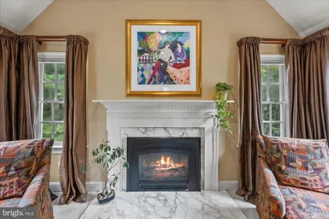 a living room with a fireplace windows and a fireplace